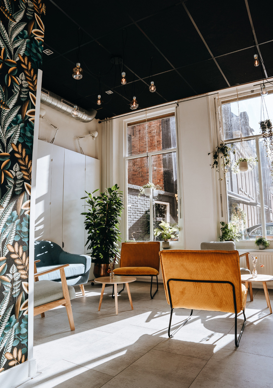 Het interieur van Luhu met zitplaatsen, planten en grote ramen